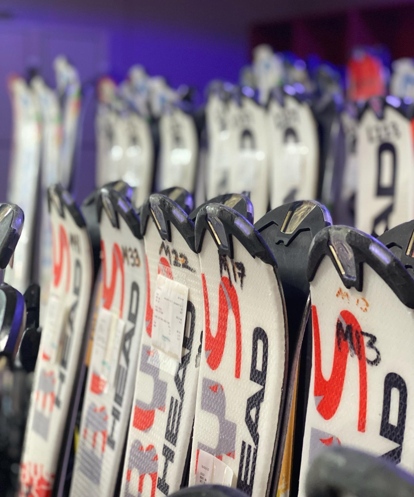 tips of ski lined up in rental shop