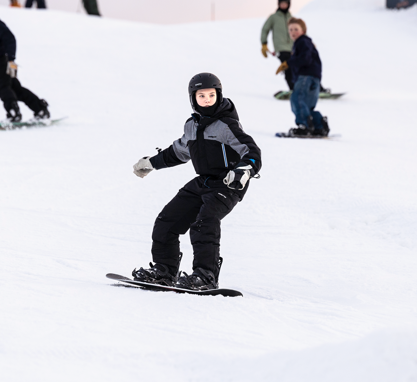 kid going down hill on snowboard