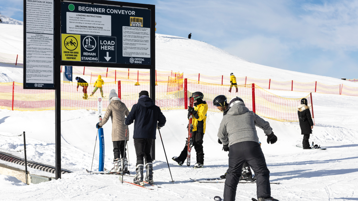 people loading onto conveyor belt on bunny hill