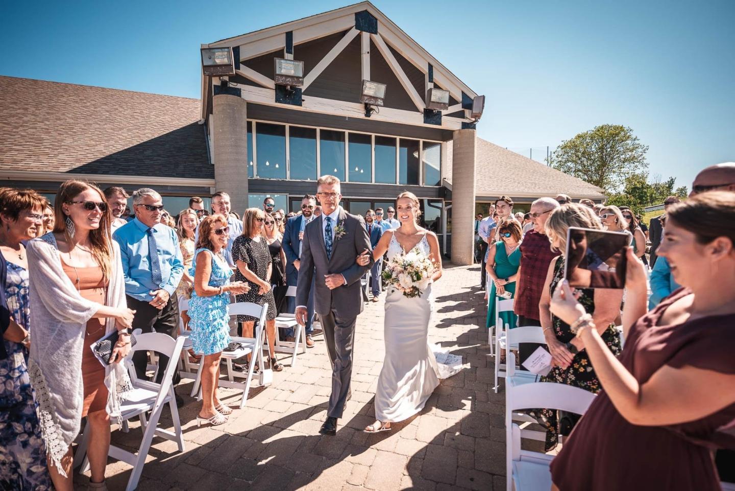 Bride and groom walk down the aisle at an outdoor wedding ceremony.
