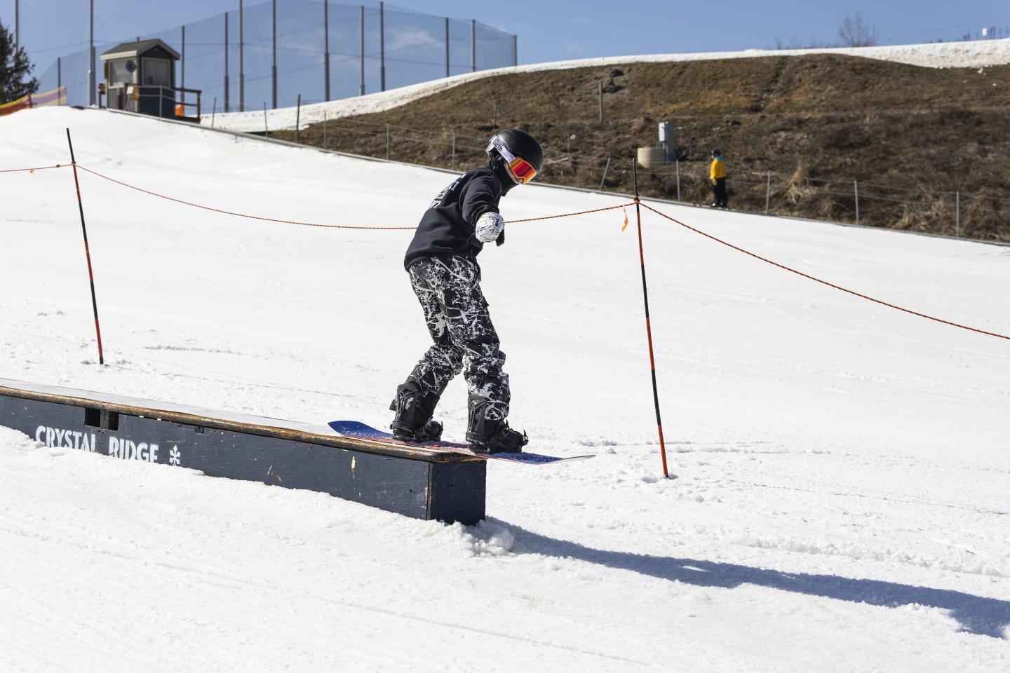 Snowboarder sliding on a rail at Ridge 