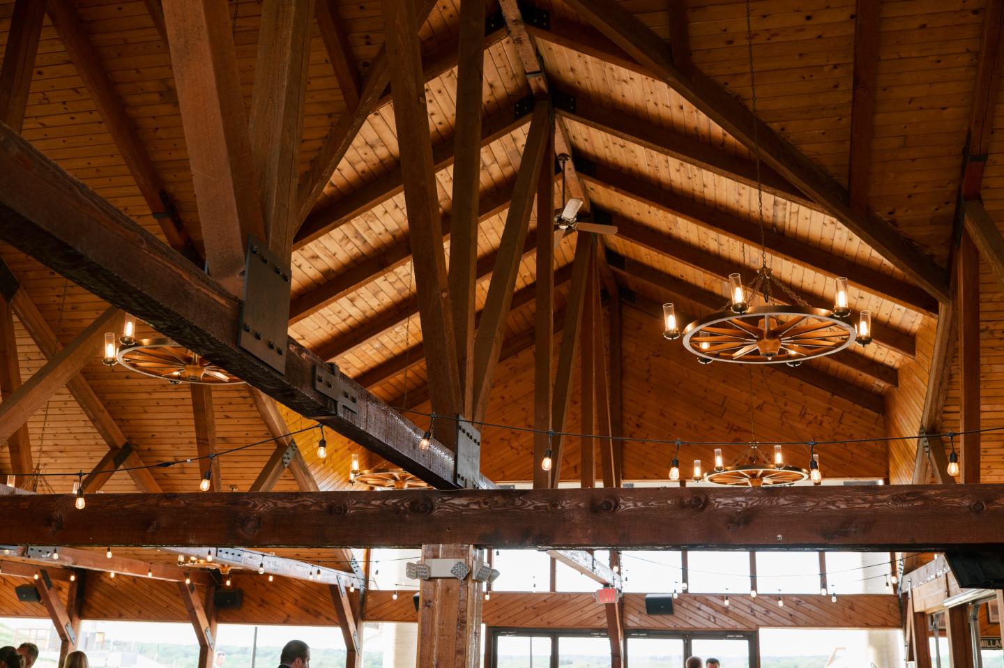 Wooden ceiling with large beams and decorative chandeliers.