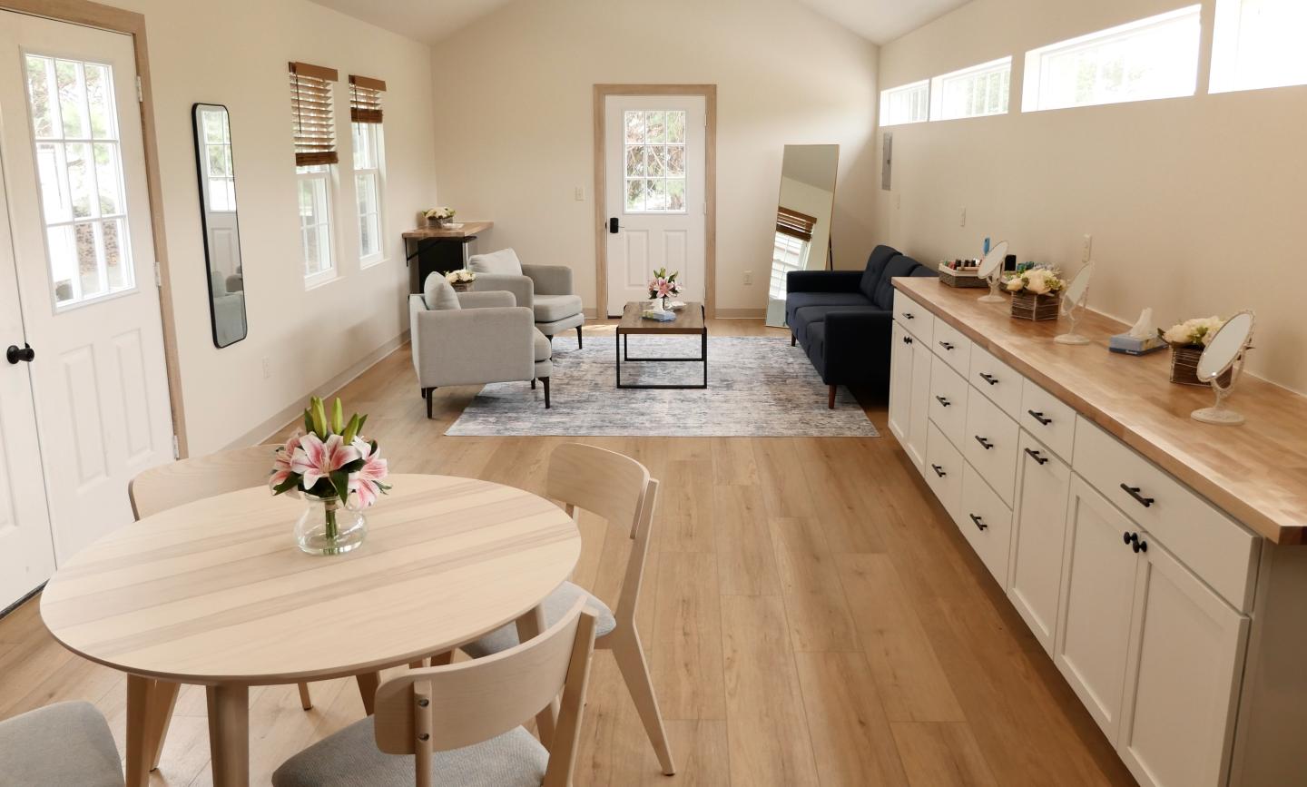 Bright open-plan kitchen and dining area with wood floors and white cabinetry.