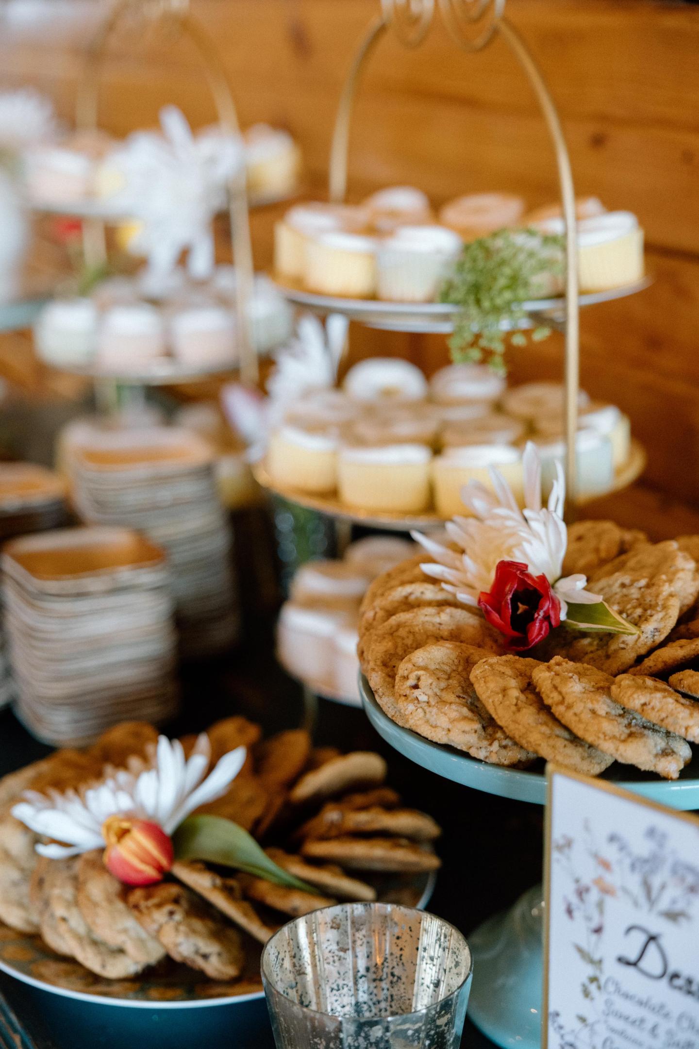 Rustic buffet table with pastries, bread, vegetables, and a small red flower.