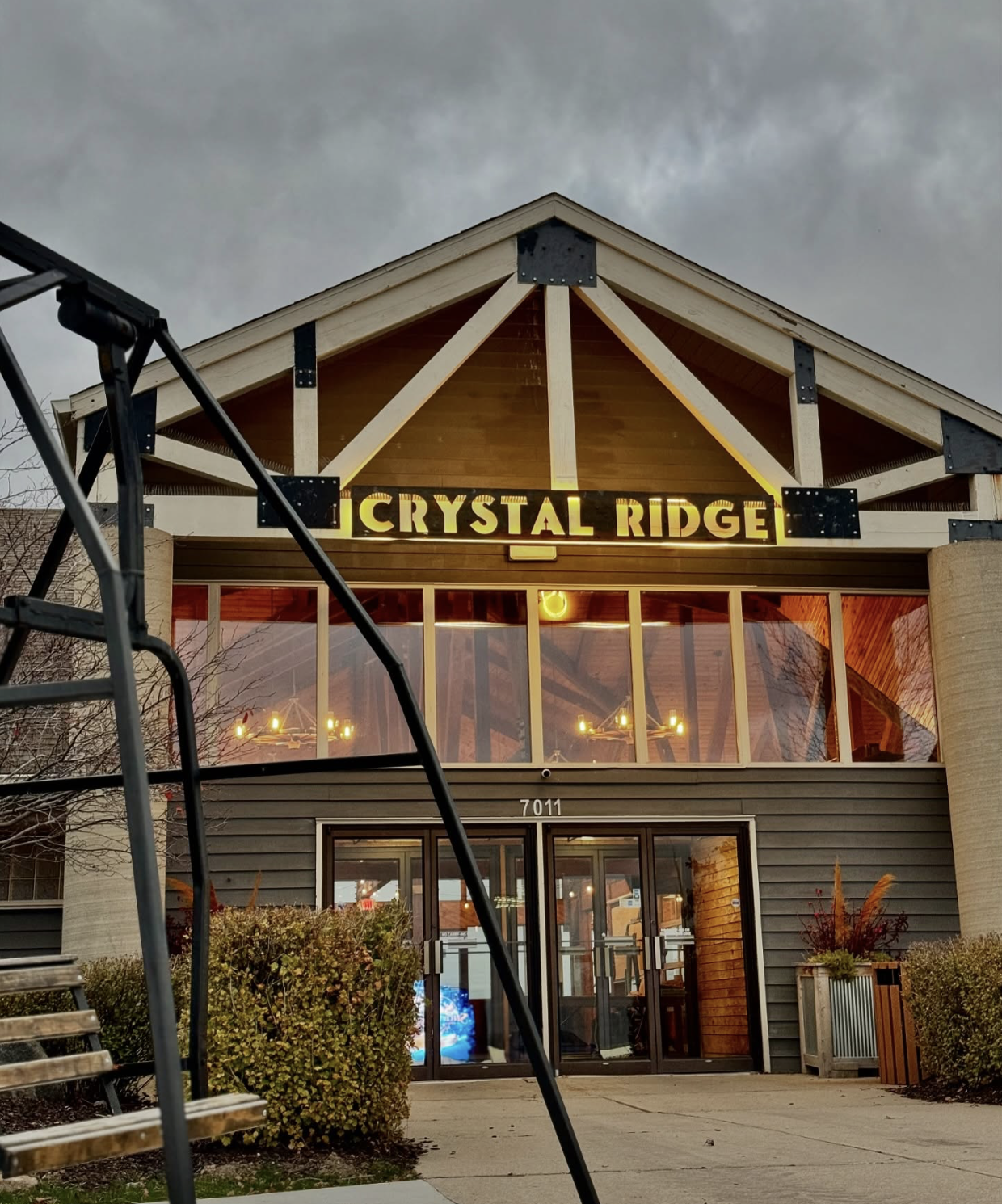 Crystal Ridge storefront with illuminated sign beneath a gabled roof on a cloudy day.