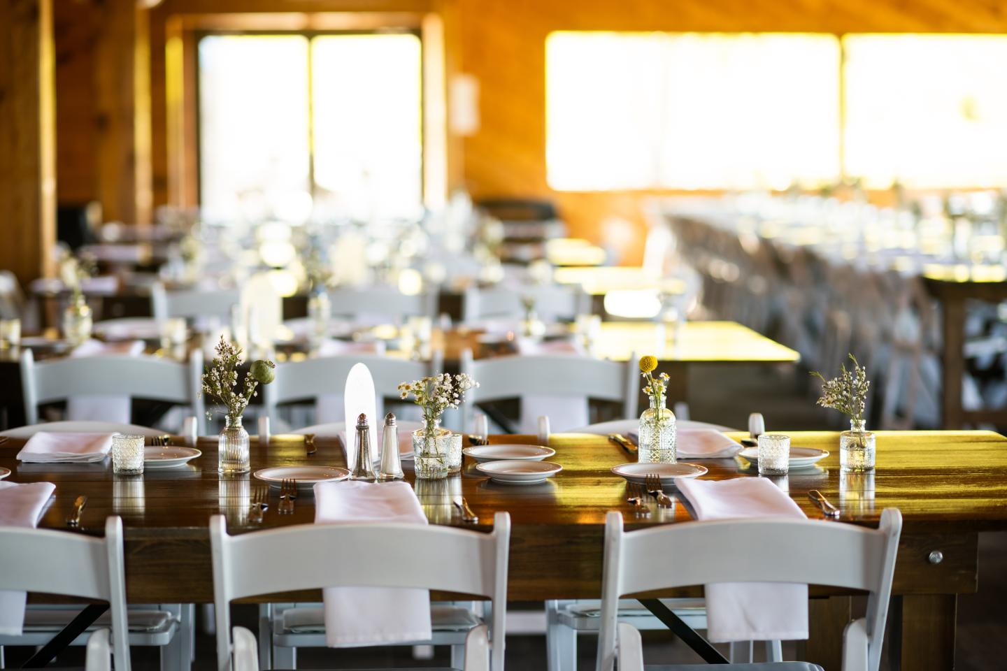Sunlit restaurant dining room with neatly set tables and white chairs