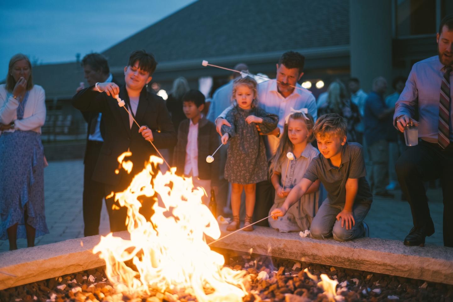 People gathered around a bright campfire at dusk.